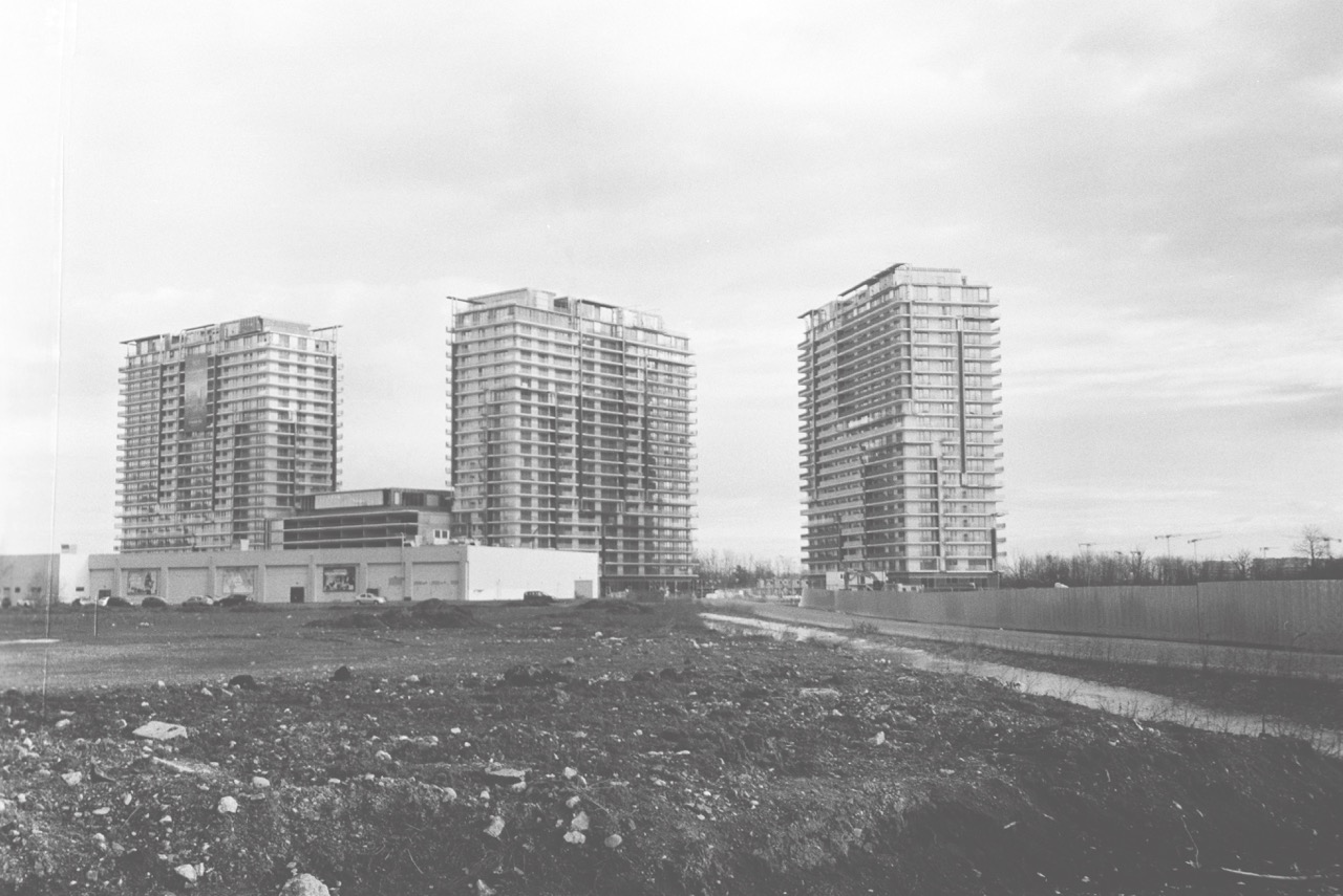 New apartment blocks and hypermarket in front of a muddy field